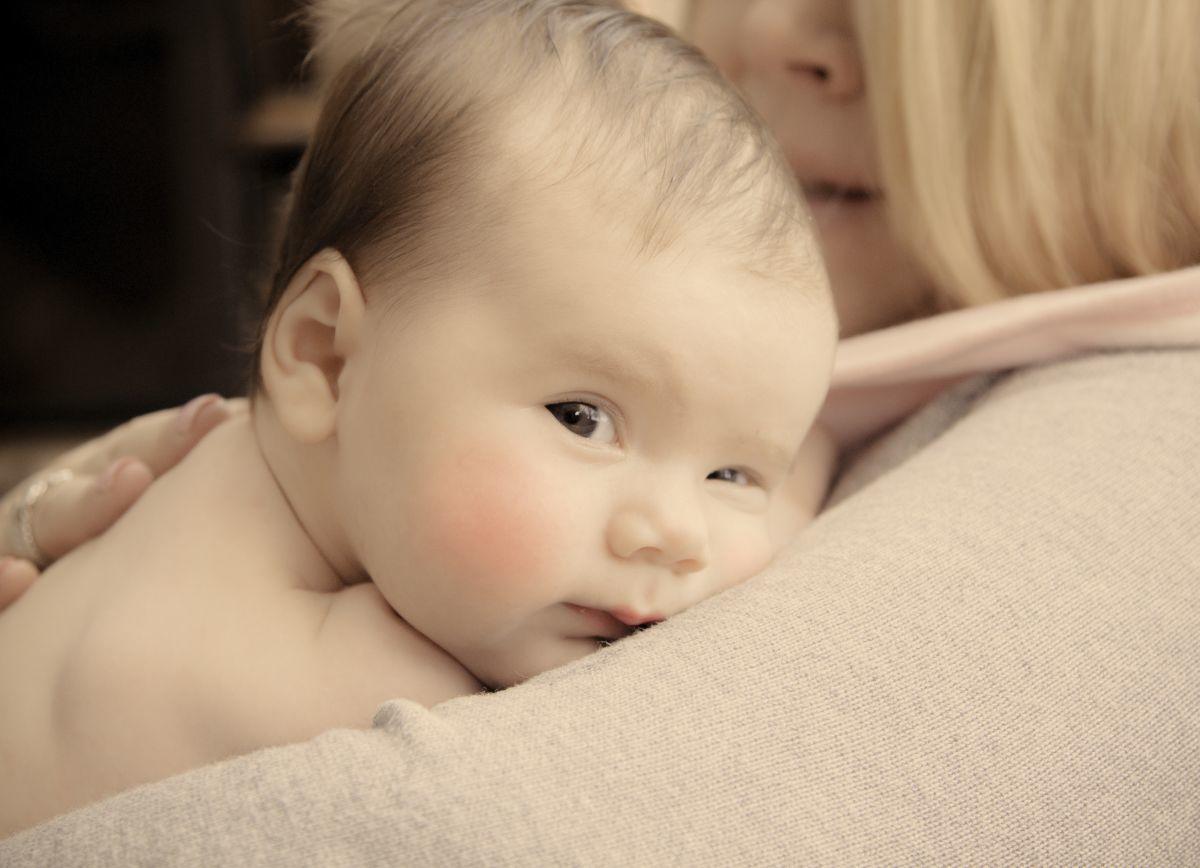 Mutter trägt das Baby im Arm