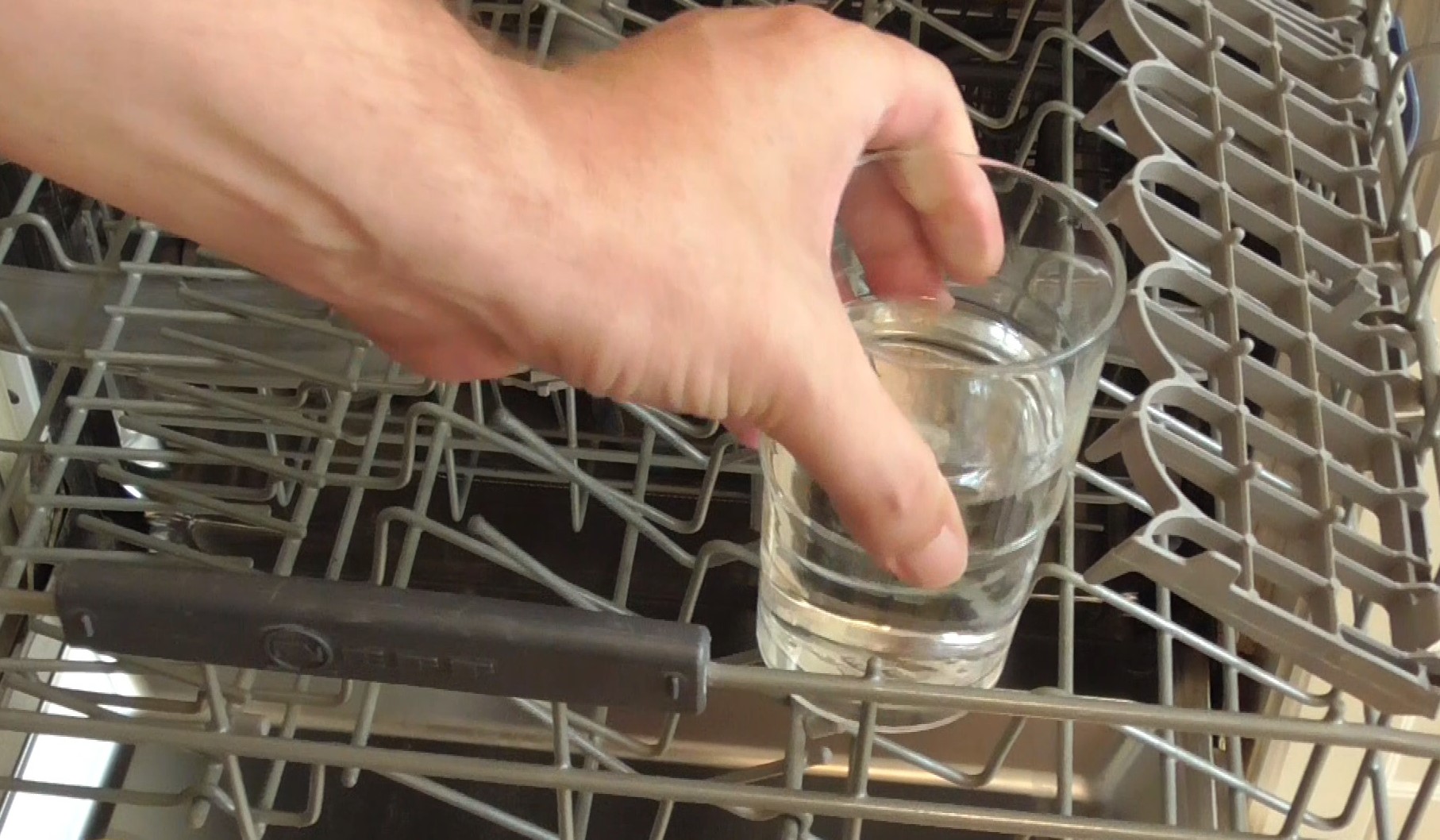 Glas mit Essig in Gläser Ablage der Spülmaschine